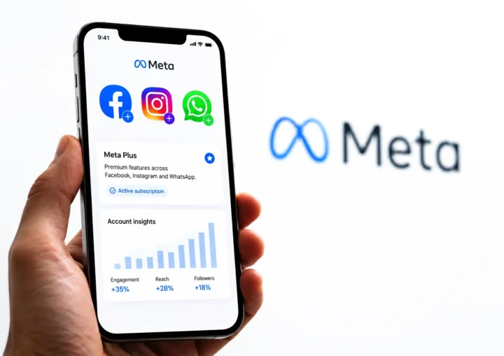 Hand holding a smartphone with a Meta Plus subscription interface for Facebook, Instagram and WhatsApp.